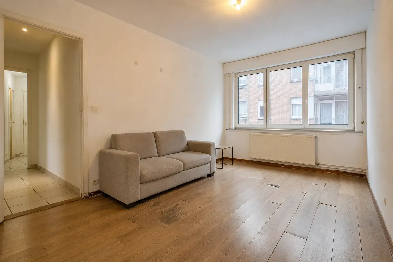 Living room with damaged, lifted wooden floorboards